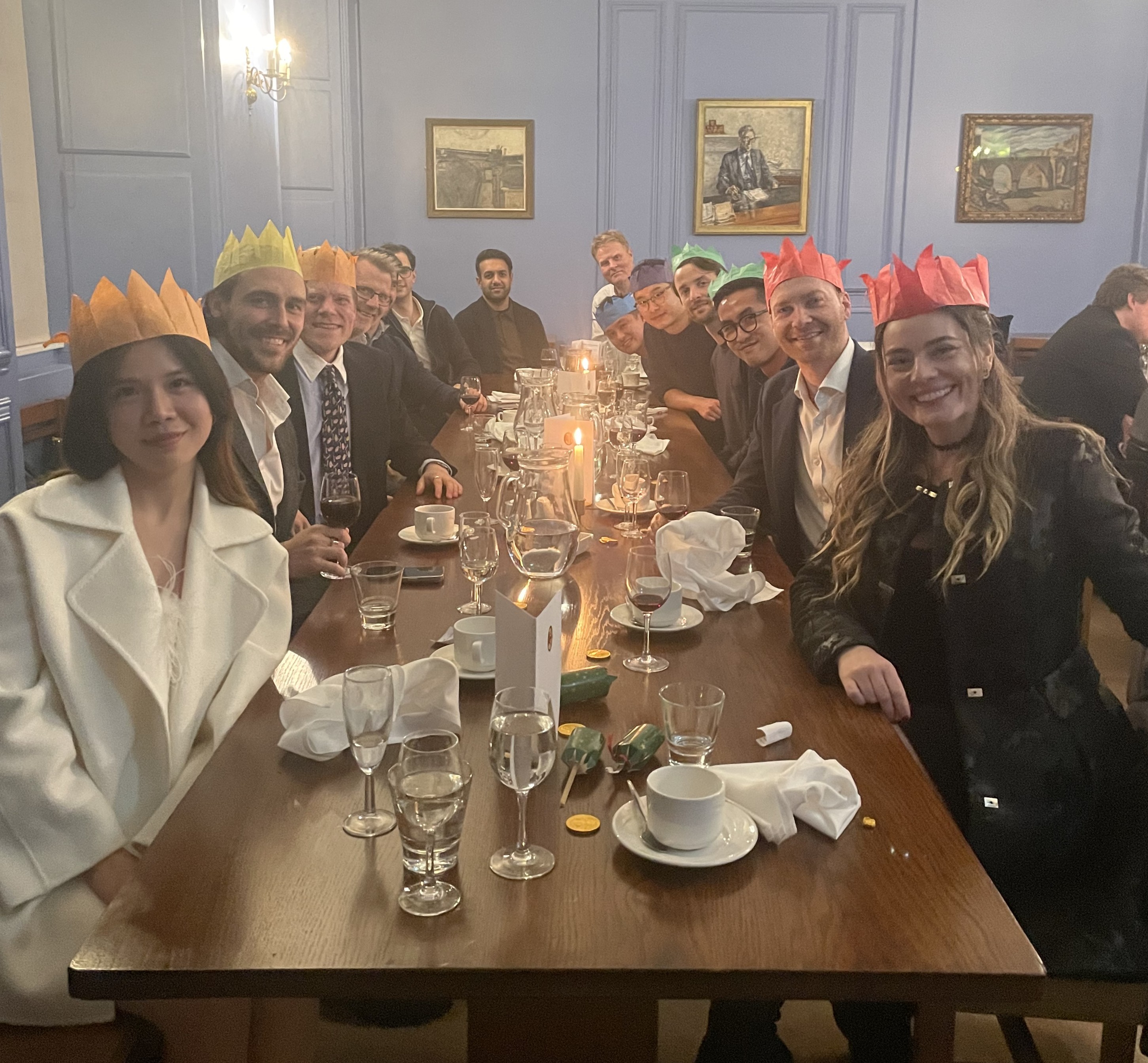 Photograph showing MSt students sitting at a dining table wearing Christmas hats