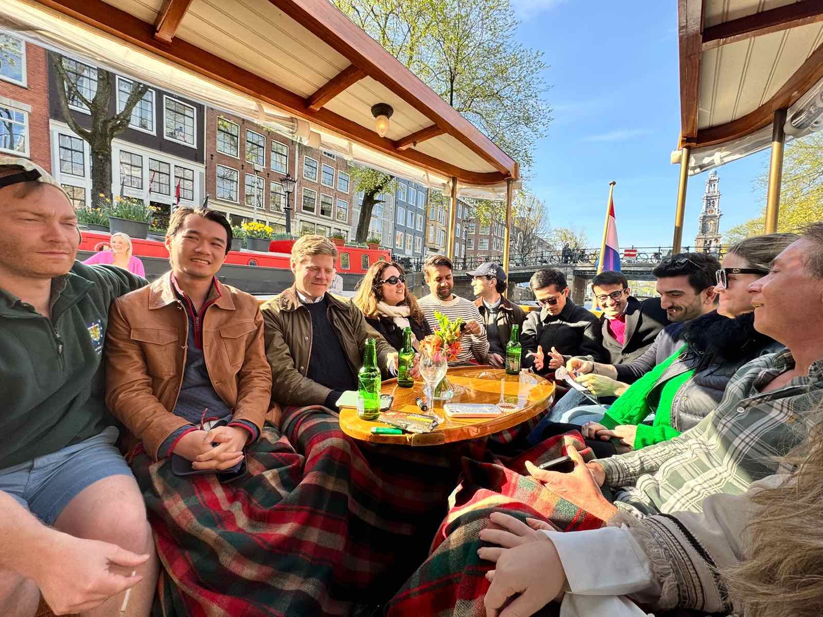 A photograph of MSt in Real Estate students sitting around a table in a canal boat in Amsterdam, during one of their site visits.