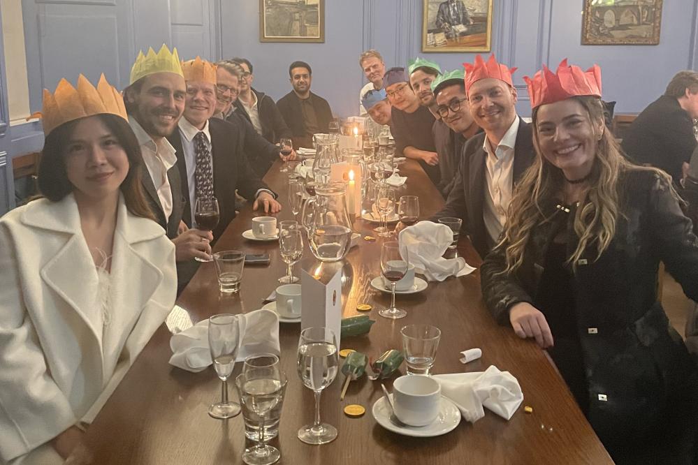 Photograph showing MSt students sitting at a dining table wearing Christmas hats