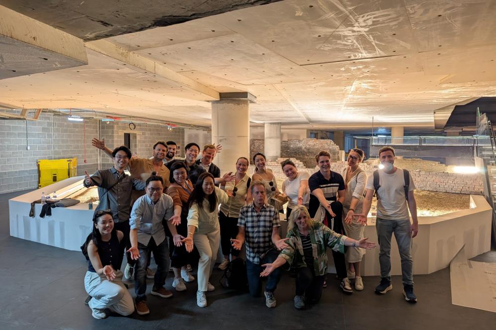 A photograph of MSt in Real Estate students in an underground concrete space, posing theatrically.